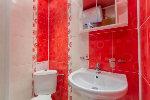 a red bathroom with a toilet and a sink at La Casa Primorsko in Primorsko