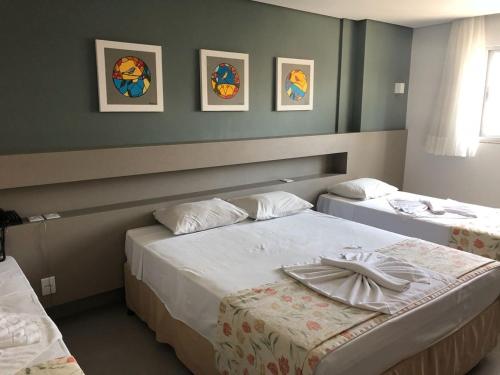 two beds in a hotel room with two beds at Hotel Morada do Sol in Caldas Novas