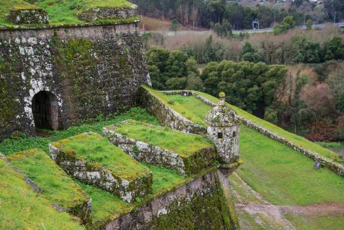 an old building with grass on the side of it at Hostel Bulwark in Valença
