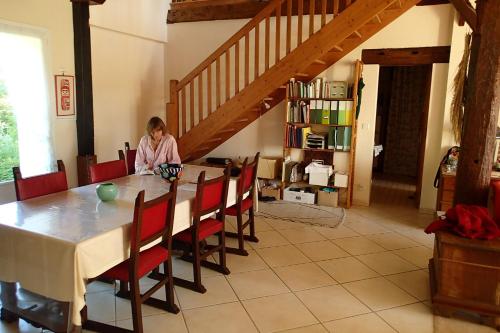 Ein Mädchen, das an einem Tisch im Esszimmer sitzt. in der Unterkunft Ricouch, chambre d'hôtes et permaculture in Momuy