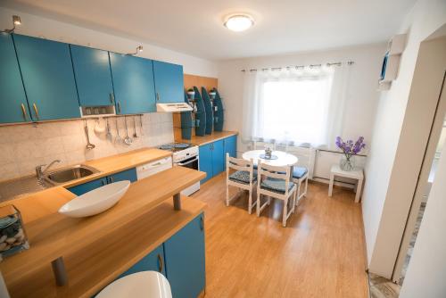 Krška VasにあるApartments Stankovoのキッチン(青いキャビネット、テーブル、椅子付)