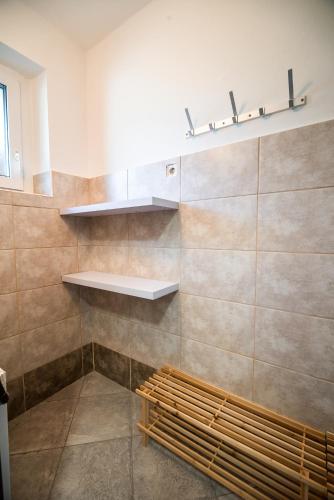 a bathroom with a bench and a shelf on the wall at Apartments Stankovo in Krška Vas
