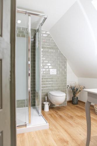 a bathroom with a glass shower in a attic at Le manoir des chevaux dorés in Le Neubourg