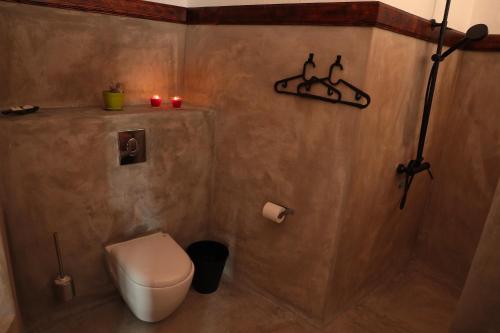 a bathroom with a toilet and candles on the wall at Casa Colonial Koenig in São Filipe