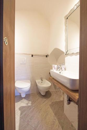 a bathroom with a white toilet and a sink at Agripodere Il Falco in Pontremoli