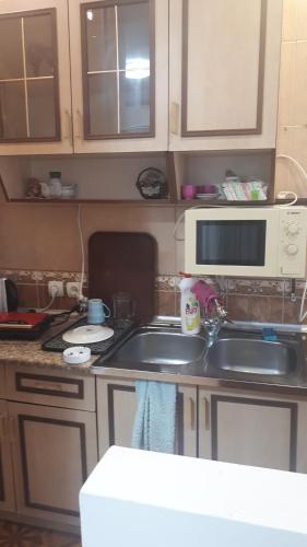 a kitchen with a sink and a microwave at Enjoy The Hostel in Batumi