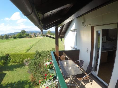 a balcony with chairs and a view of a field at Landhaus Klopein in Sankt Kanzian