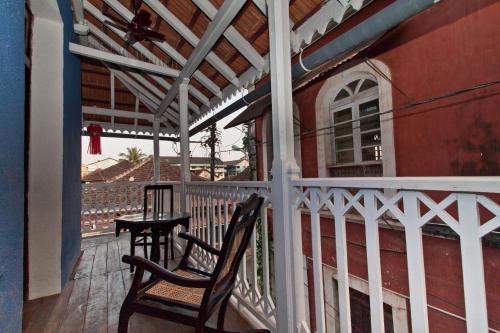 a balcony with two chairs and a table on it at Hospedaria Abrigo De Botelho in Panaji
