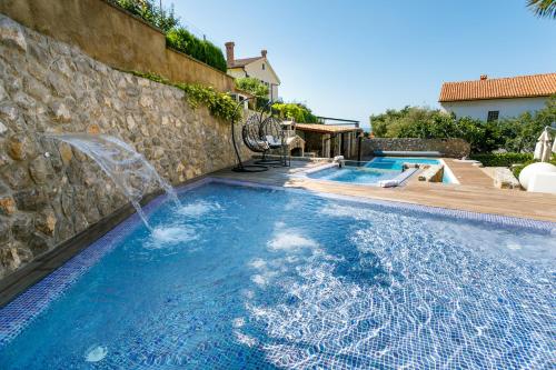 a swimming pool with a water fountain in a house at Villa Palma Krk in Krk