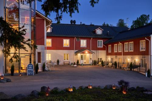 un grand bâtiment avec des bâtiments rouges et blancs dans l'établissement Hotel Villa Molnby, à Porvoo