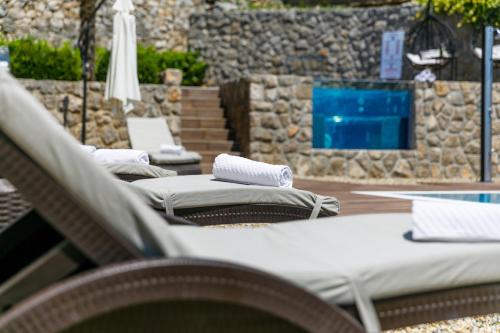 a row of lounge chairs sitting next to a pool at Villa Palma Krk in Krk