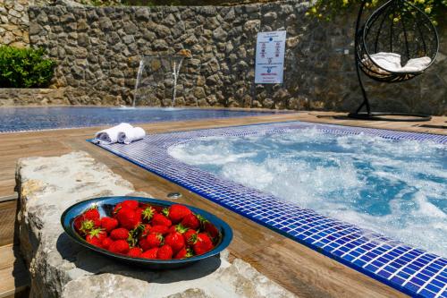 a bowl of strawberries sitting next to a swimming pool at Villa Palma Krk in Krk