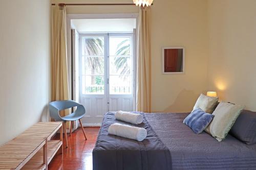 Un dormitorio con una cama azul y una ventana en Downtown Ponta Delgada, en Ponta Delgada