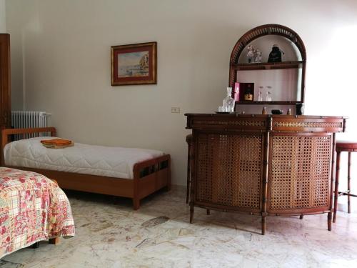 una camera con letto, cassettiera e specchio di La Ozza B&B a Otranto