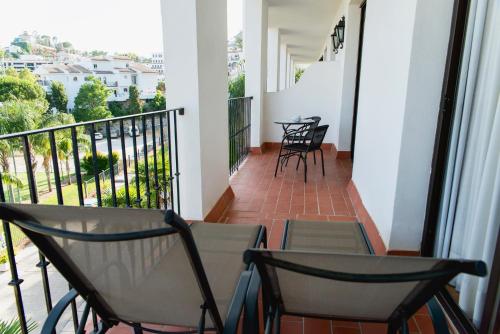 a balcony with two chairs and a table and chairs at TRH Mijas in Mijas