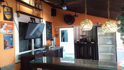 a living room with a television and a table at Airport Pousada in Cabo Frio