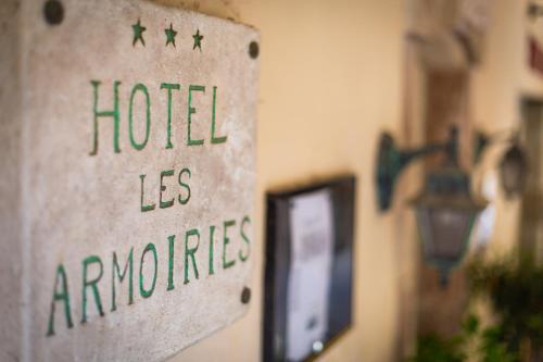 a sign that reads hotel ans appliances on a wall at Hotel les Armoiries in Valbonne