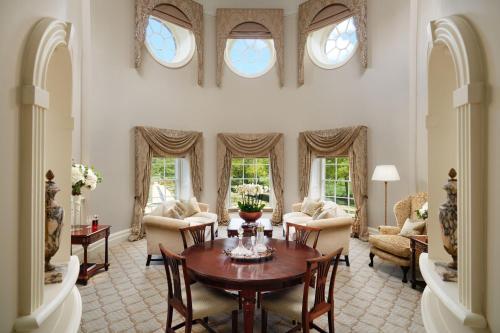 a living room with a table and chairs and windows at Grantley Hall in Ripon