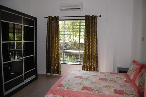 um quarto com uma cama e uma grande janela em Marco Polo Rest House em Kuching