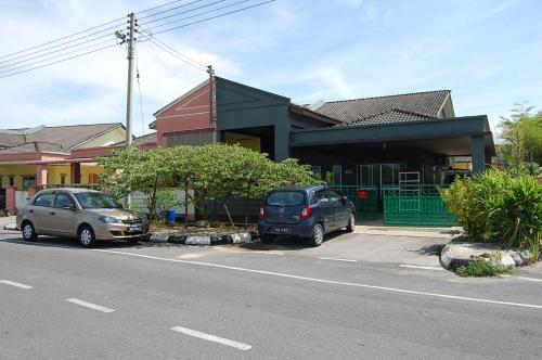 two cars parked in a parking lot in front of a building at Marco Polo Rest House in Kuching