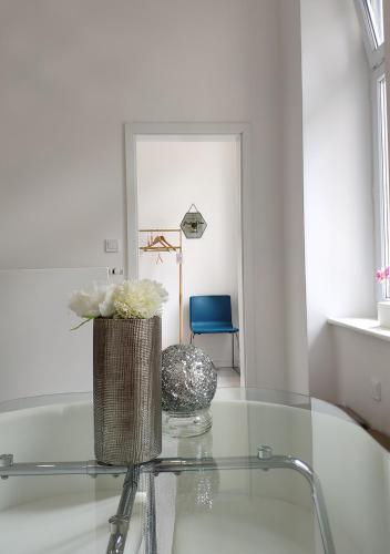 a glass table with a vase of flowers on it at Luxurios and historic apartment "Shine" - right on the Main Square in Zagreb