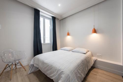 een slaapkamer met een bed, een stoel en een raam bij Nouveau F2 calme cœur de ville 1min de la plage in Saint-Raphaël