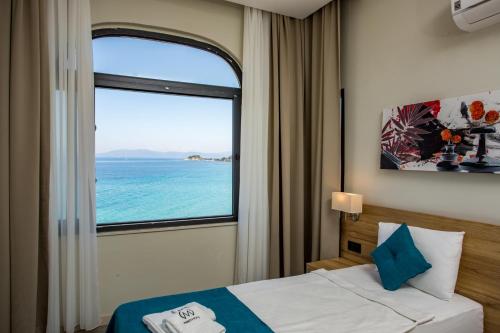 a bedroom with a bed and a large window at Marti Beach Hotel in Kuşadası