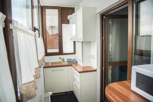 a small kitchen with white cabinets and a sink at Adma Apartments in Sibiu