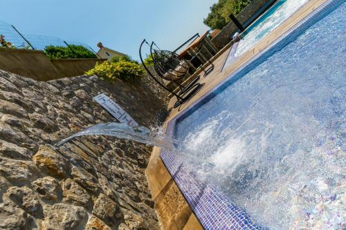 a swimming pool with water coming out of it at Apartments Petra Krk in Krk