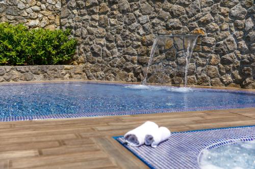 a white cat laying on a mat next to a fountain at Apartments Petra Krk in Krk