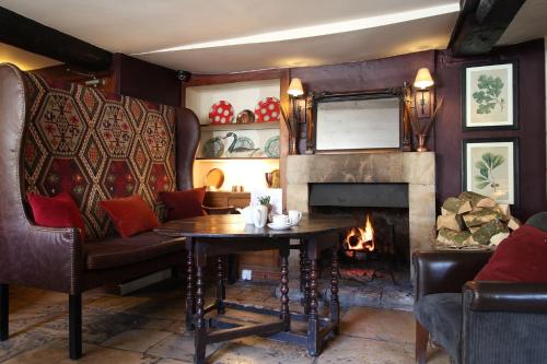 a living room with a table and a fireplace at The Lamb Inn in Burford