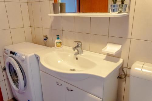 a bathroom with a sink and a washing machine at Apartment Katia in Pula