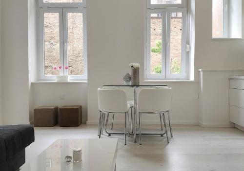 a living room with a table and white chairs at Luxurios and historic apartment "Shine" - right on the Main Square in Zagreb