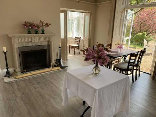 a living room with a table and a fireplace at Scarborough Hill Country Inn in North Walsham