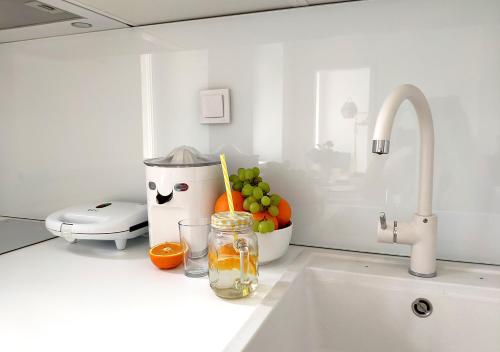 a kitchen counter with a sink with fruit and a juicer at Luxurios and historic apartment "Shine" - right on the Main Square in Zagreb
