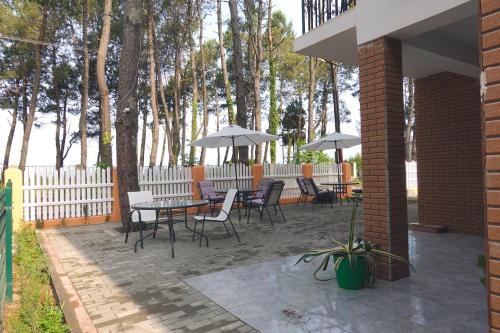 a patio with a table and chairs and umbrellas at GiNa Shekvetili in Shekvetili