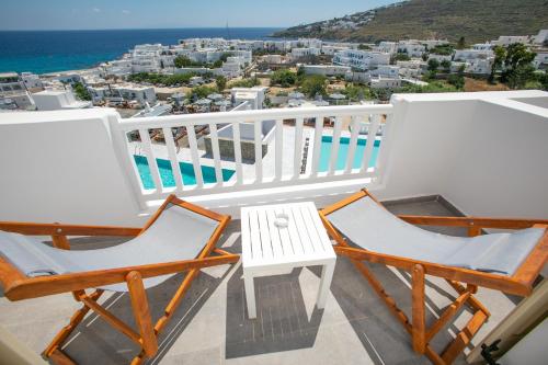 a balcony with two chairs and a table at The George Hotel Mykonos in Platis Gialos