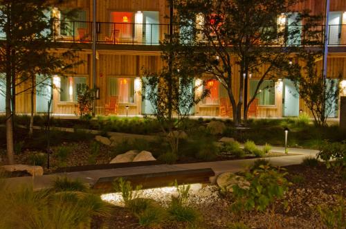 a building with a garden in front of it at night at Lone Star Court, by Valencia Hotel Collection in Austin