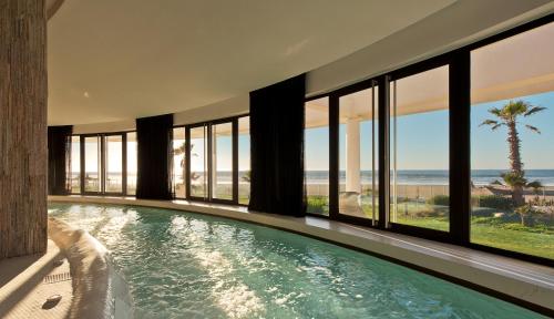 a house with a swimming pool with a view of the ocean at Sofitel Agadir Thalassa Sea & Spa in Agadir