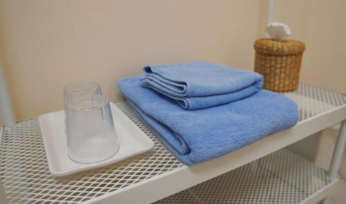 a shelf with towels and a glass of water on it at INN Room in Bangkok
