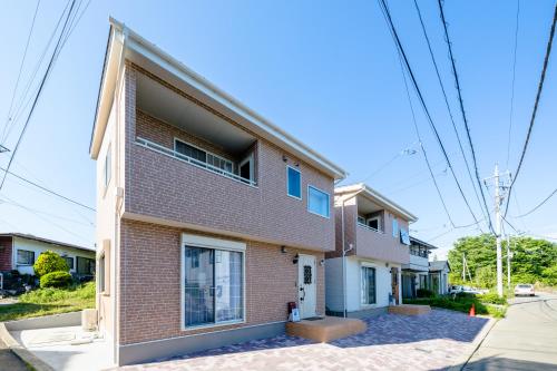 a brick house on a street at villa hanasaku 富士河口湖町A棟 in Fujikawaguchiko