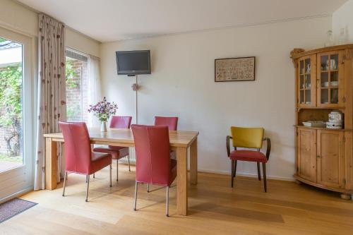 a dining room with a wooden table and chairs at B&B Schipborg in Zuidlaren