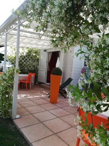a patio with orange chairs and a white pergola at Villaggio Turistico dei Tigli in Padenghe sul Garda