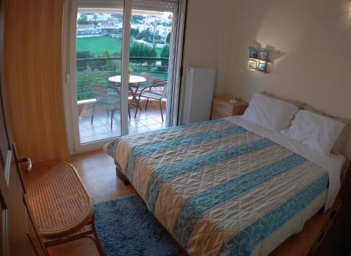 a bedroom with a bed and a balcony with a table at Villa Evridiki in Fourka