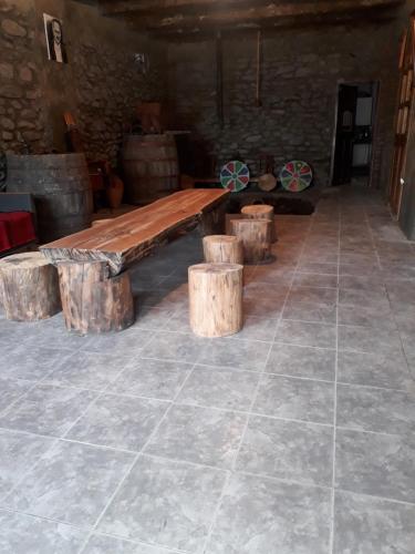 a wooden table and some logs in a room at Hotel E U R O P E in Kvareli