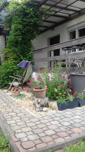 a garden with flowers and a bench and a table at Aliz Apartman in Nyíregyháza