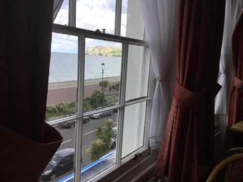 a window with a view of the ocean from a hotel room at THE TREVONE, Llandudno in Llandudno