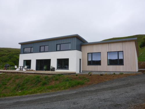 a house on the side of a hill at Stones Luxury B&B with hot tub and self-contained rooms in Uig