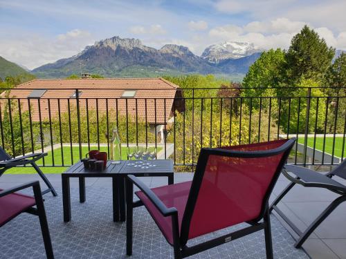 d'une terrasse avec une table, des chaises et des montagnes. dans l'établissement Appartement Lac, à Sévrier