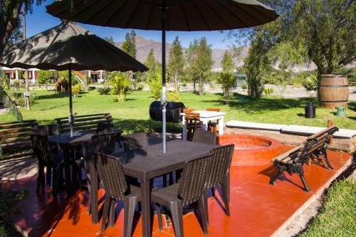 a patio with tables and chairs and an umbrella at Casa Hacienda Nasca Oasis in Nazca